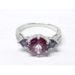 A hallmarked 9ct white gold ring set with a central pink topaz and two heart shaped cut blue