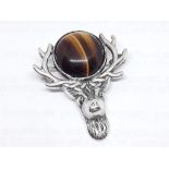 A Scottish silver brooch modelled as a stag's head and set with a tiger's eye cabochon, Scotia