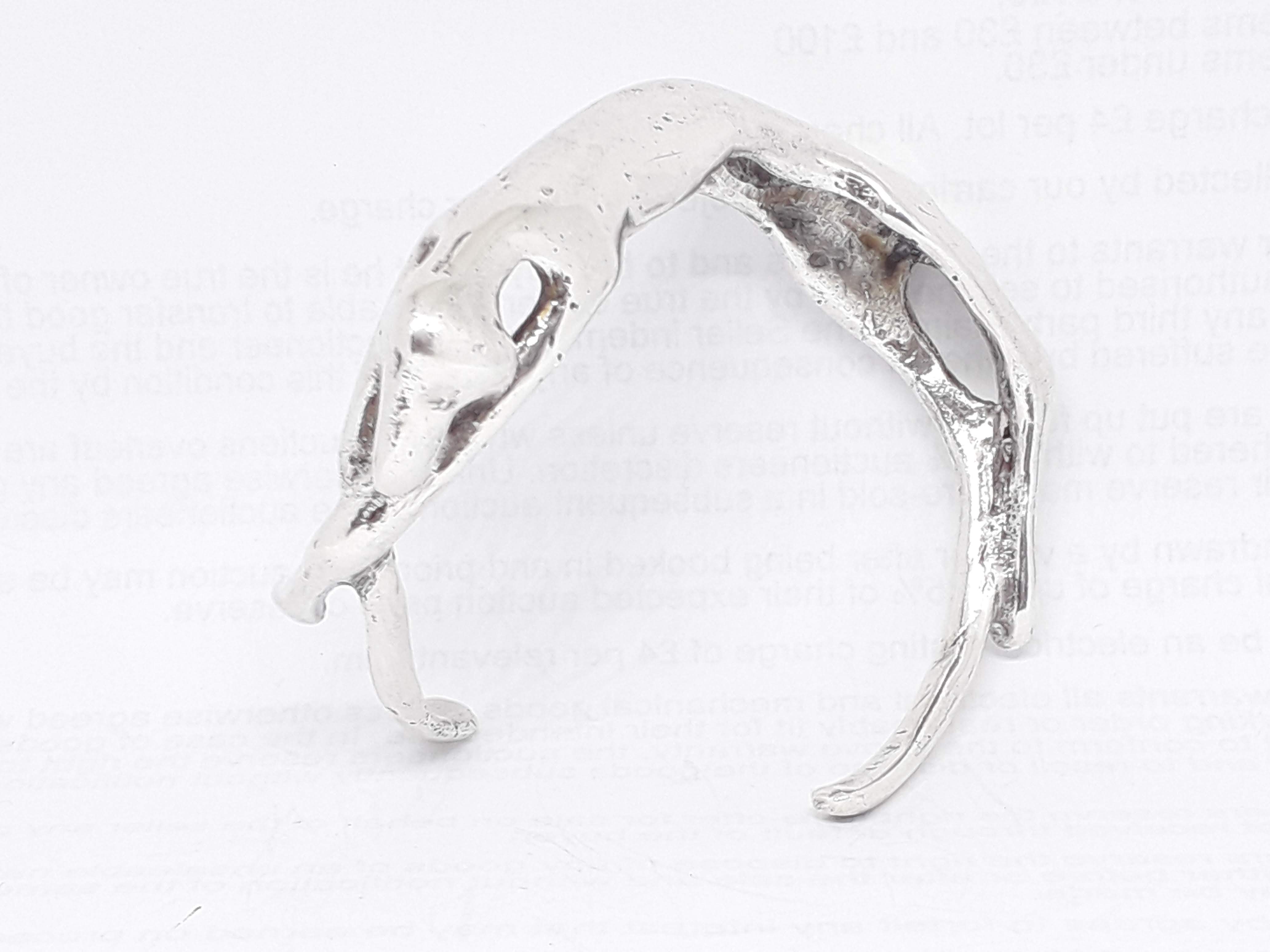 A modern silver bangle formed as a stylised sleeping dog, spnsor's mark 'JPT', London 1978, wt. 78.