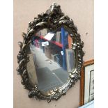 An ornate gilt framed oval mirror