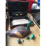 A box with wooden decoy duck and small leather suitcase