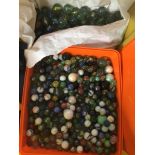 A box of small marbles and a bag of large marbles.