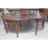 A 19th century mahogany dining table in the manner of Gillows with reeded legs and brass capped