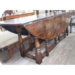 An 18th century style large oak wake table and six ladder back chairs, probably by Titchmarsh and