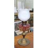 An Art Nouveau brass and pink glass oil lamp, height 60cm. There is a slight chip to the clear