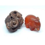 A Japanese amber netsuke and a carved wooden netsuke.