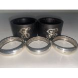 A pair of Antique 1915 hallmarked silver napkin rings, one other 1912 and two ebony napkin rings
