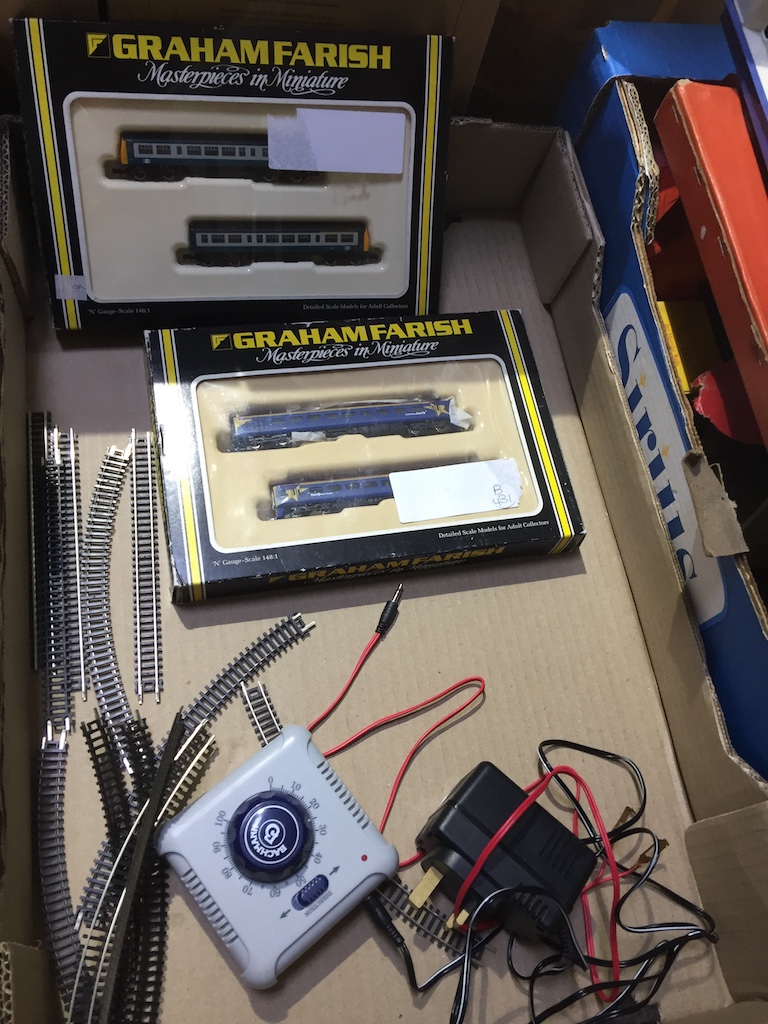 Box containing two Graham Farish model trains, Bachmann controller unit and a quantity of track.