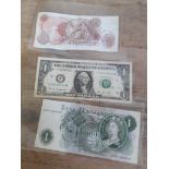 Three banknotes, one pound, ten shillings and a dollar.