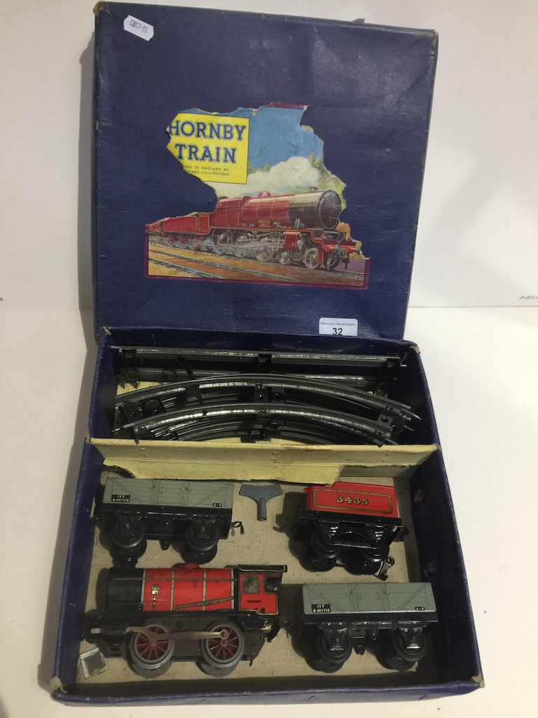 A Hornby 0 gauge clockwork goods train and 2 open waggons set with key