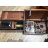 An old wooden cased magic lantern slide projector and a wooden case of glass slides