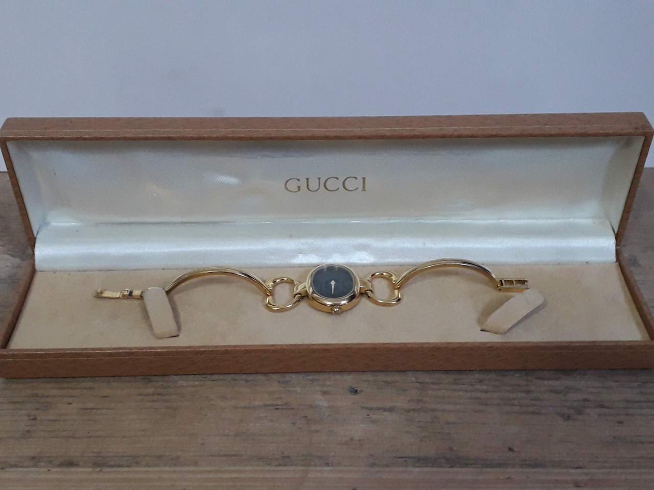 A ladies gold plated Gucci wristwatch with box.