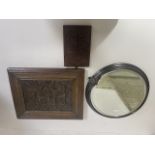 An early carved oak panel in later frame, a carved wood plaque and a circular metal framed mirror.