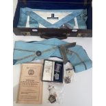 A Masonic apron and collar with various jewels/ medals in a leather case.