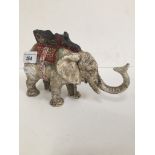 A cast iron money box in the form of an elephant, tail operates trunk to feed coins
