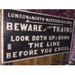 A cast iron railway sign painted black and white that reads 'LONDON & NORTH WESTERN RAILWAY: