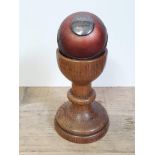 A Victorian presentation cricket ball on turned wooden stand.