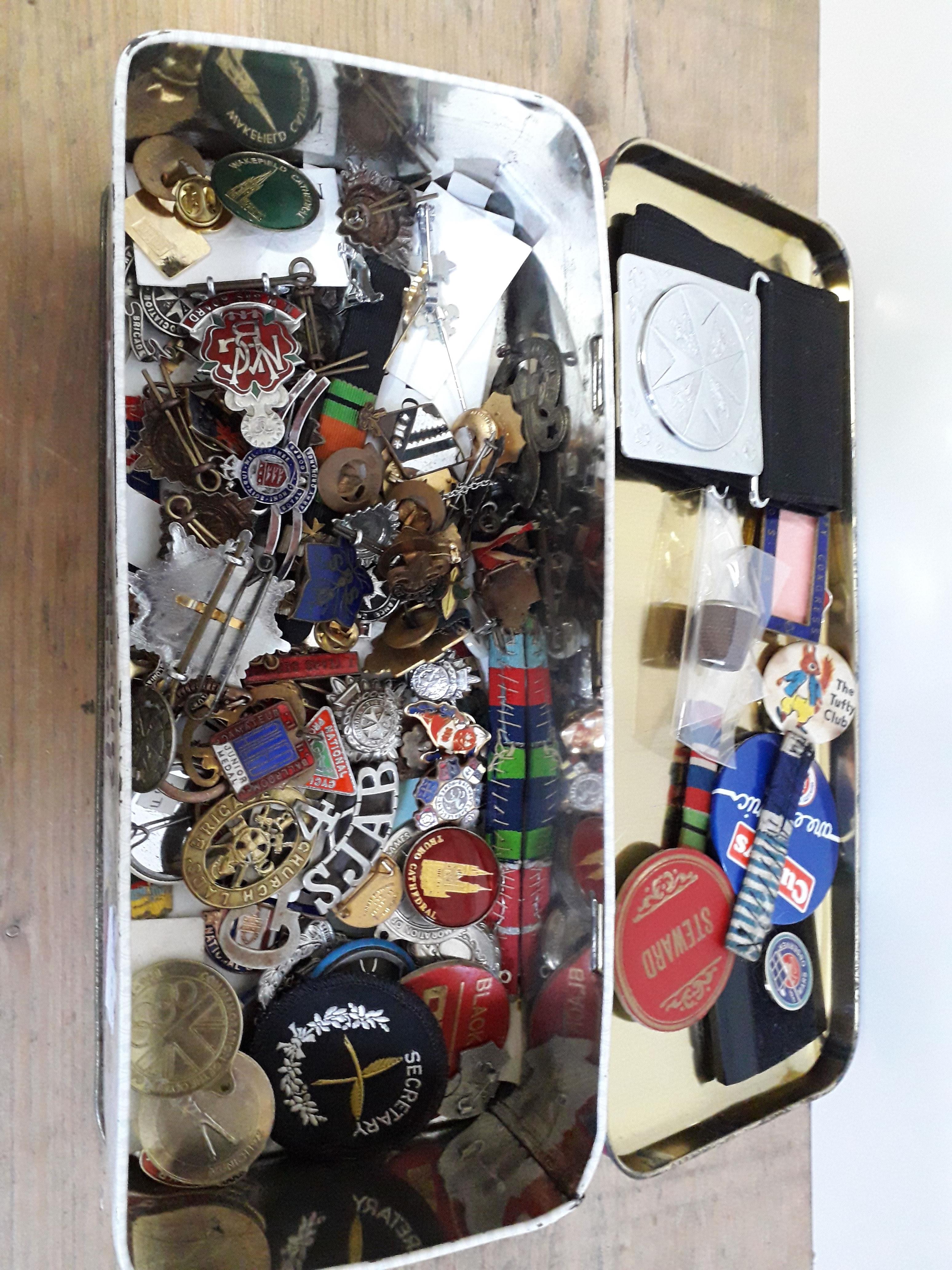 A tin of assorted badges, buttons etc.