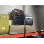 A vintage laundry case, first aid metal case, a camera case, a suitcase, a briefcase and a bundle of