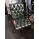 A Chesterfield style button green leather swivel office chair.