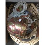 A wicker basket containing plates, various pierced plates and a copper & brass kettle