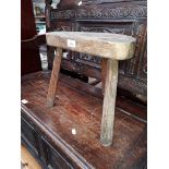 A rustic three legged oak stool.