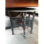 An Indian brass top table with folding carved wooden base, height 54cm and diameter 64cm