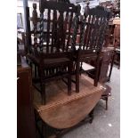 An oak drop leaf table and four chairs.