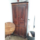 A George III cross banded mahogany corner cabinet with shell inlay.