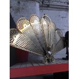 A brass fan folding fire screen