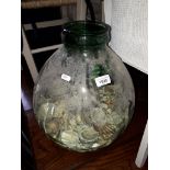 A green glass carboy half full of shells