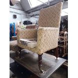 A George IV high back armchair with turned mahogany legs and brass castors.