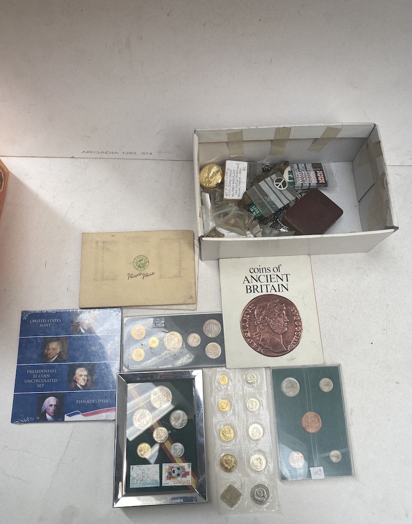 A box of world coin sets and a small box of collectables