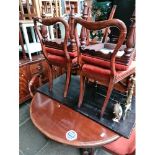 A Victorian dining table with a set of 6 chairs and 1 extra leaf