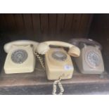 Three vintage telephones.