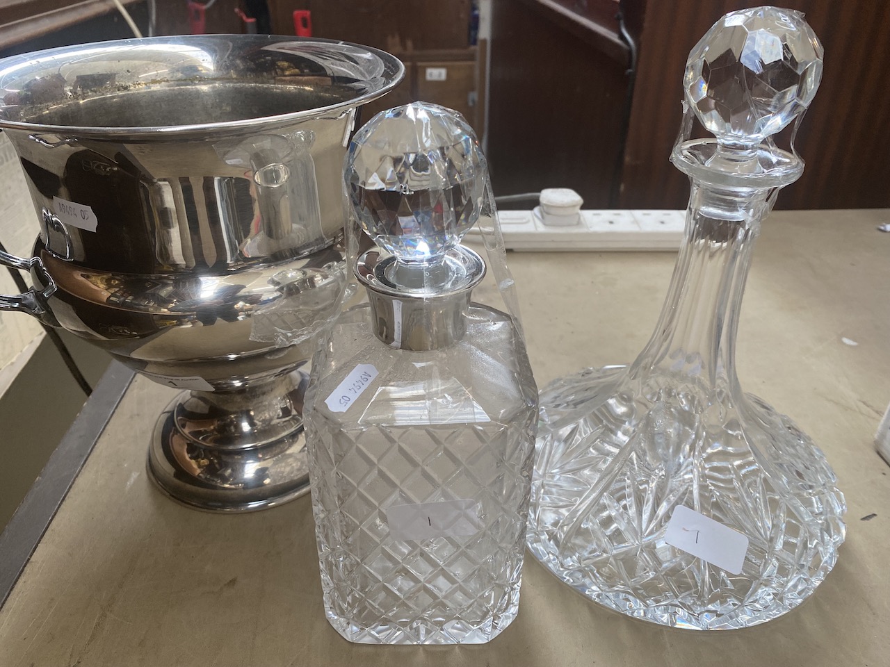 A silver plated ice bucket or campana urn form, together with two decanters.