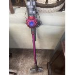 A Dyson stick vacuum with charger - in working order.