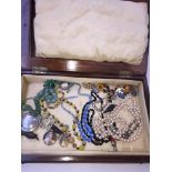 A wooden box containing costume jewellery