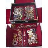 A green leather jewellery box containing costume and vintage jewellery including silver & brooches