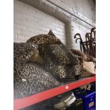 A collection of leopard print cushions, throw, bean bag, stool.