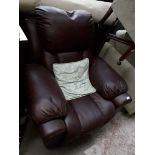A maroon leather electric recliner armchair