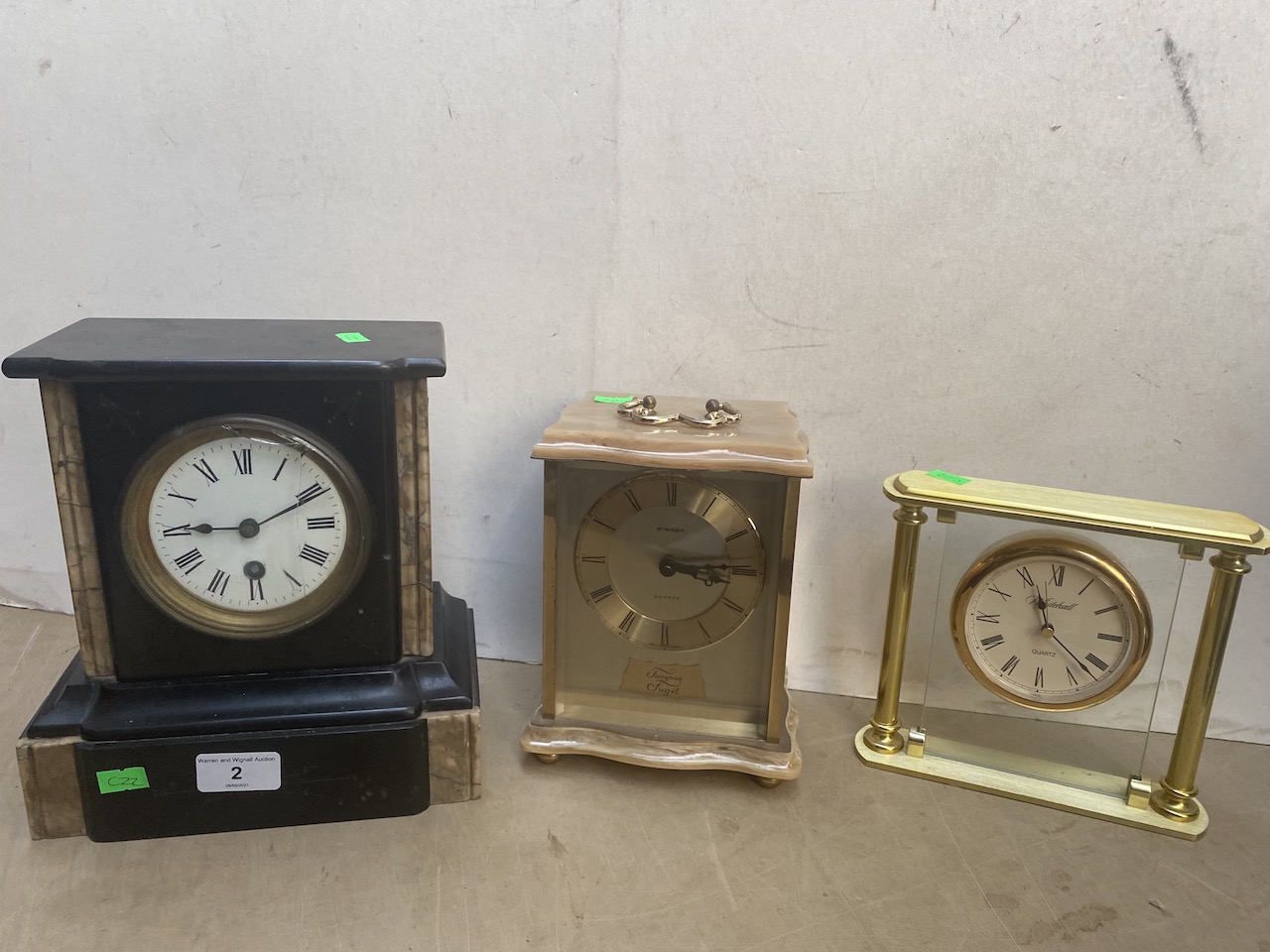 A marble slate clock, a brass and alabaster clock and another.