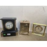 A marble slate clock, a brass and alabaster clock and another.