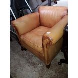 A tan leather tub chair.