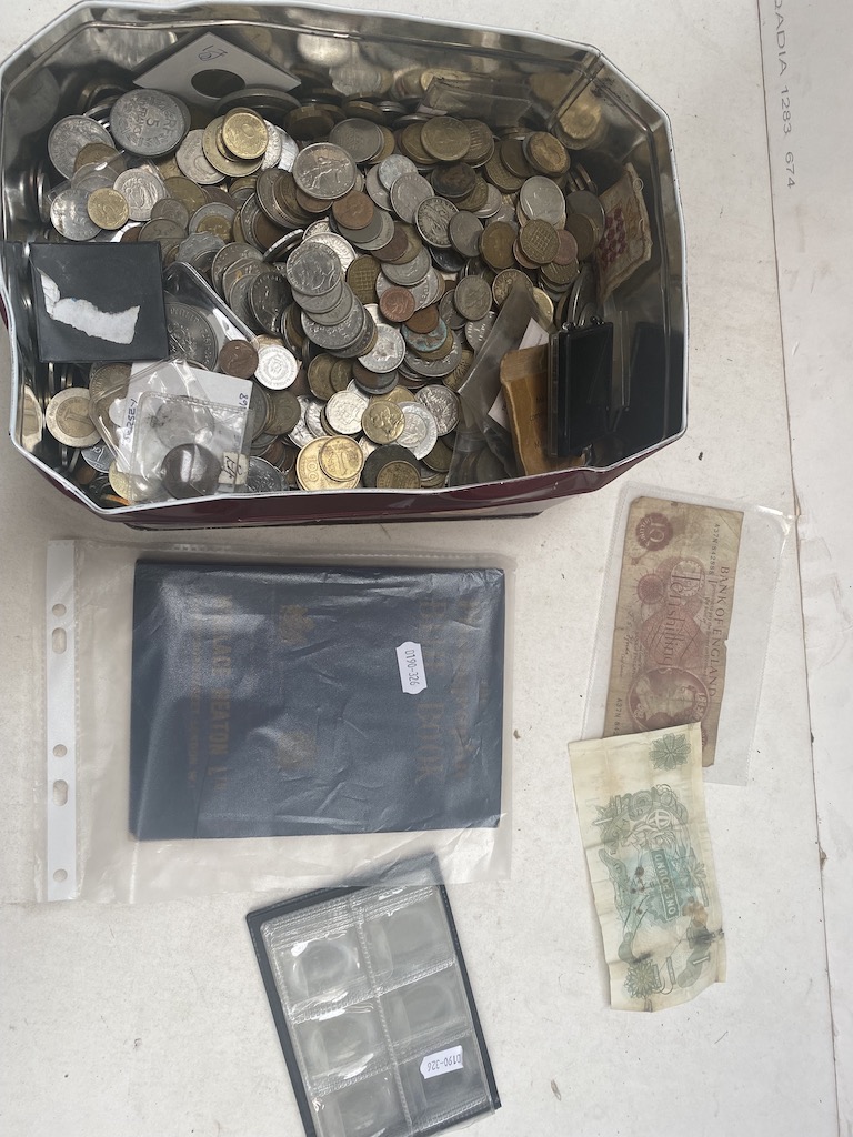 A tin of world coins and banknotes
