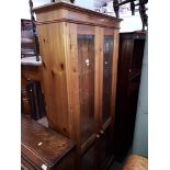 A glass fronted pine display cabinet