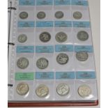 A coin album containing mainly American and Canadian 20th century coins, including USA dimes,