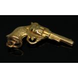 A hallmarked 9ct gold novelty charm modelled as a revolver, wt. .067g, length 22mm.