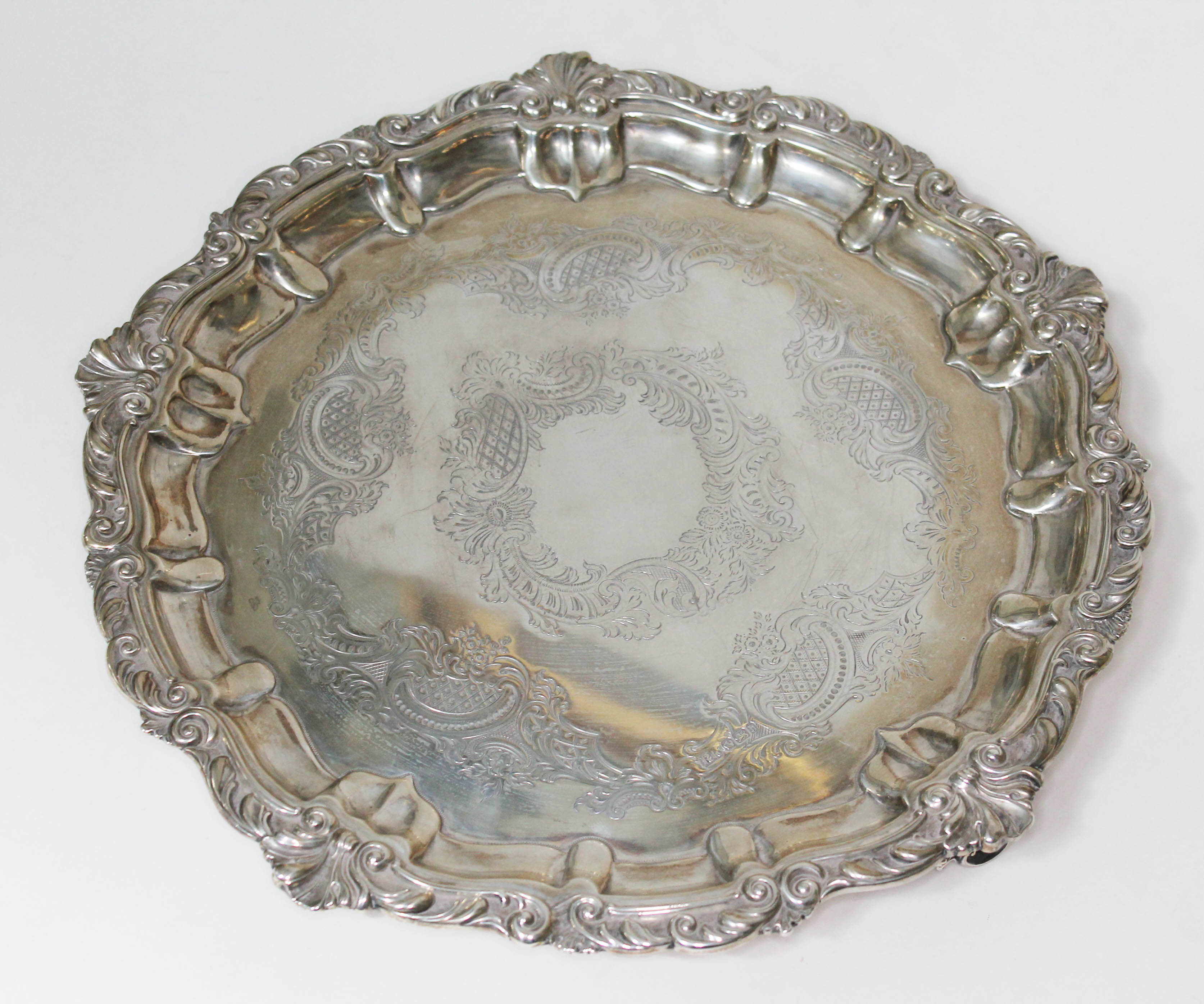A Late Victorian silver salver, scalloped edge, bright cut engraved designs to centre and raised