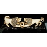 A Chinese carved ivory figure, circa 1900, depicting two lion's fighting over a puzzle ball, on